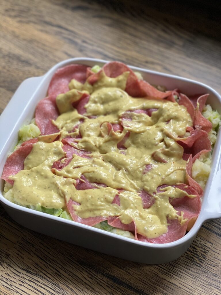 Bechamelsaus over prei ovenschotel met salami verdelen