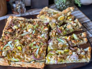 courgette plaattaart met prei en feta recept op een houten plank in stukken gesneden