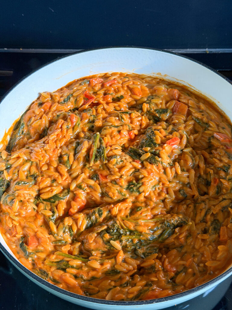 orzo in romige tomatensaus laten garen