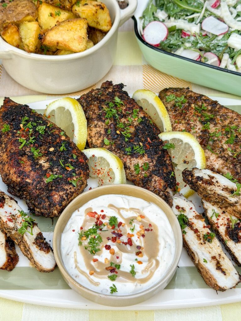 kip met za'atar en citroen, geserveerd met tahini yoghurtdressing, aardappeltjes en salade