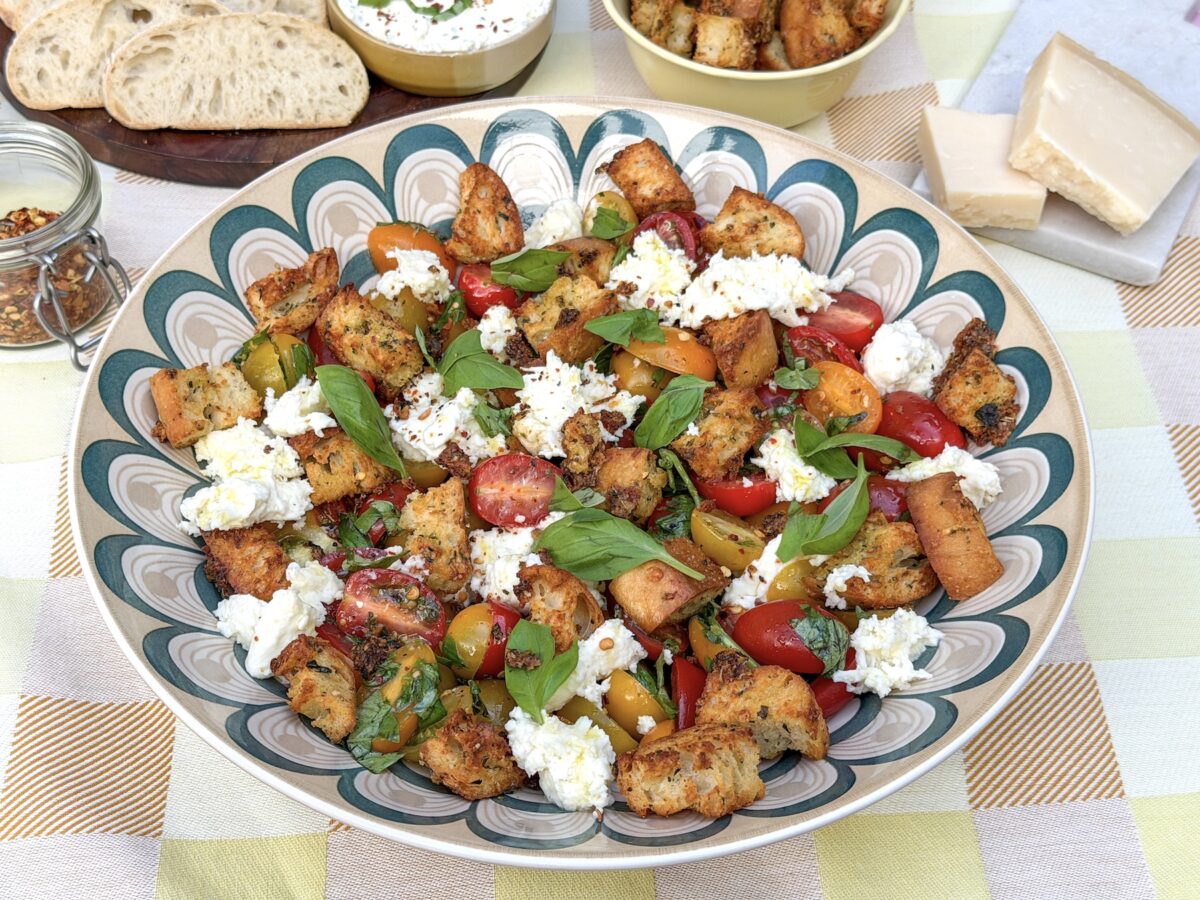 Bruschetta salade met mozzarella, gekleurde snoeptomaatjes, basilicum en knoflookcroutons