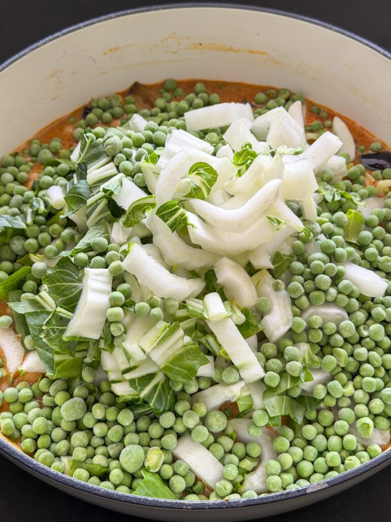 paksoi, kikkererwten en doperwten toevoegen aan Thaise gele curry