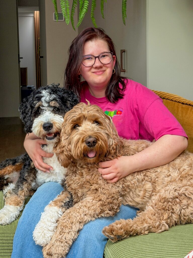 Beaudine knuffelt met de honden op de bank