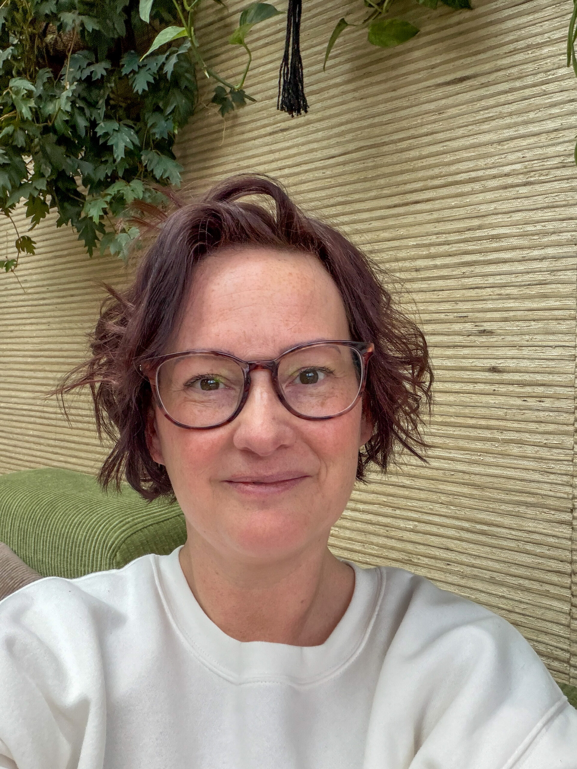 Marie Louise maakt een selfie op de groene bank in de woonkamer.