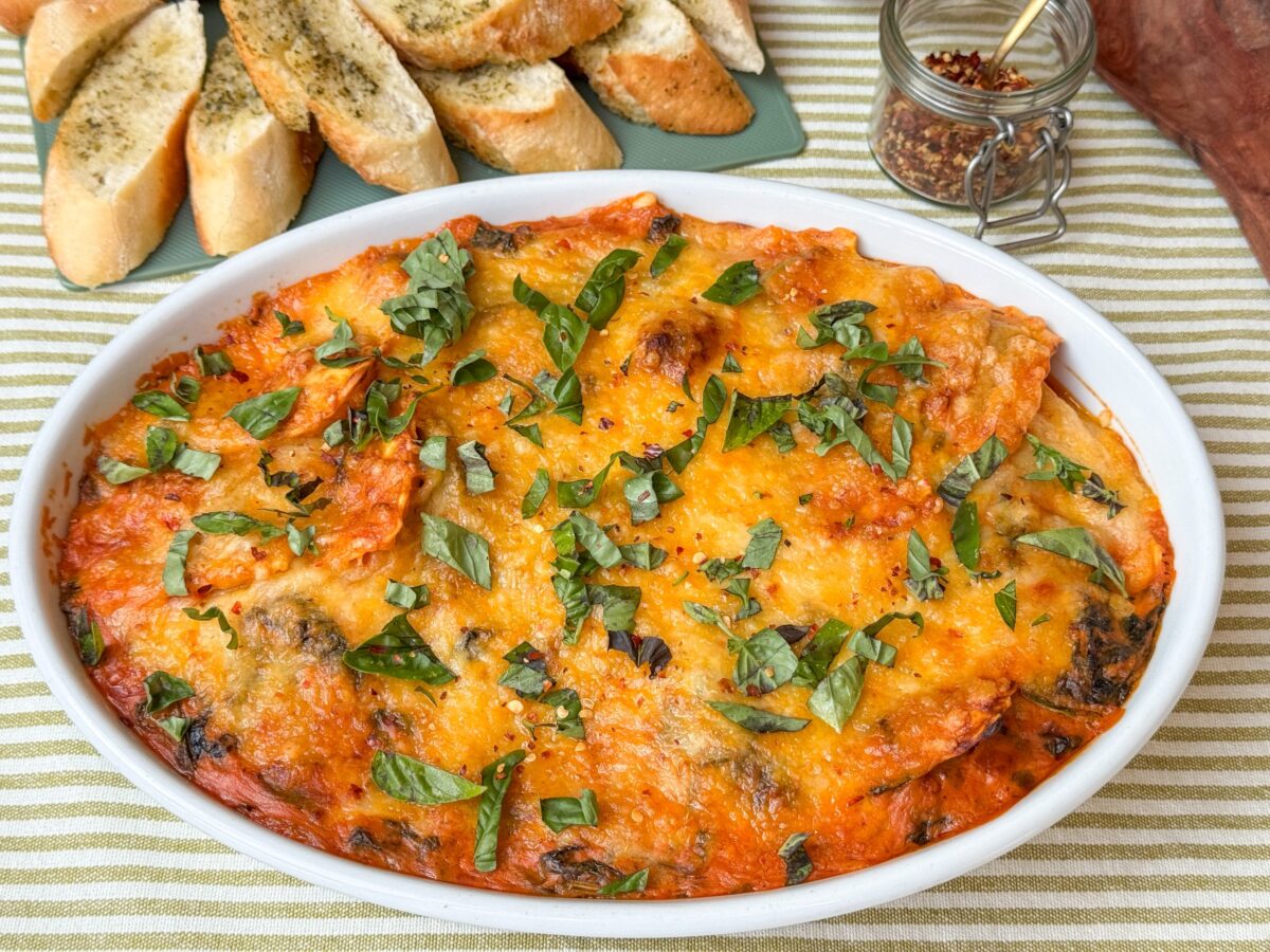 Ravioli ovenschotel met spinazie en romige tomatensaus met gesmolten kaas in ovenschaal