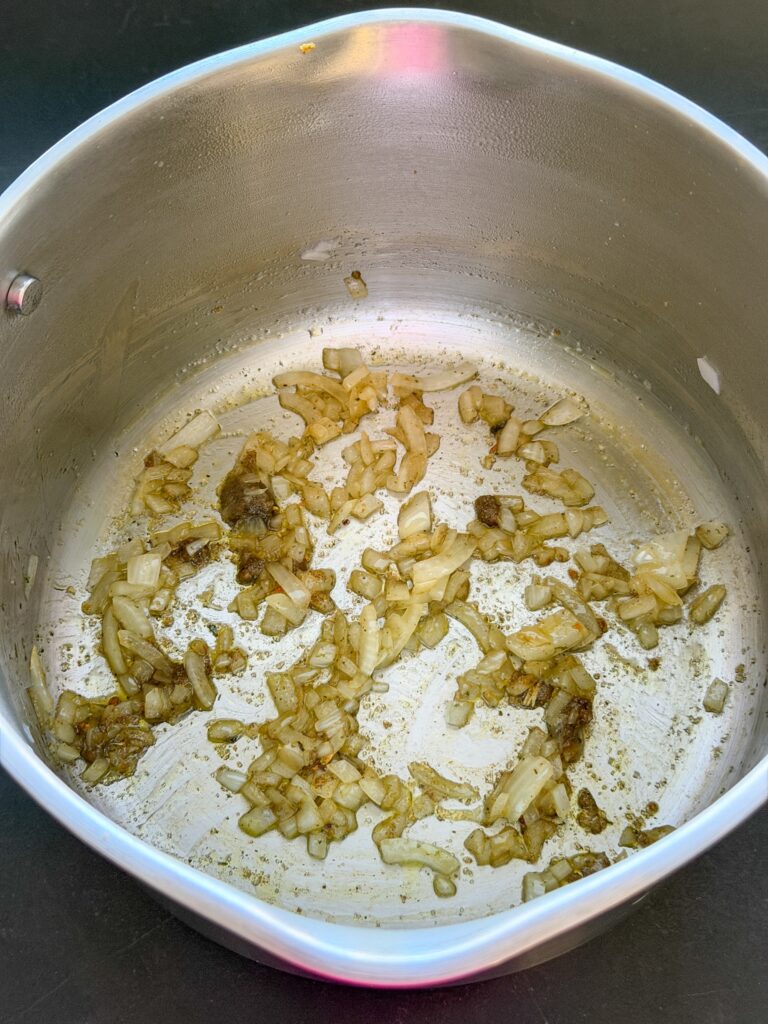 gesnipperde ui en bouillonblokje bakken in pan
