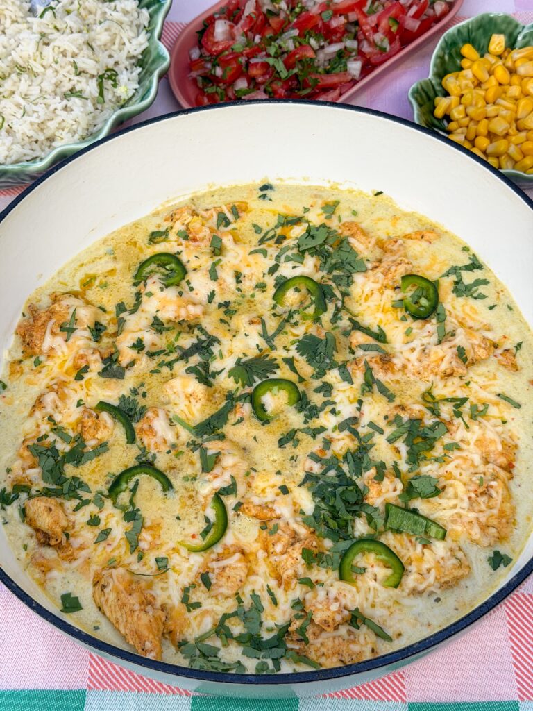 romige mexicaanse kip met groene salsa en gesmolten kaas in de pan