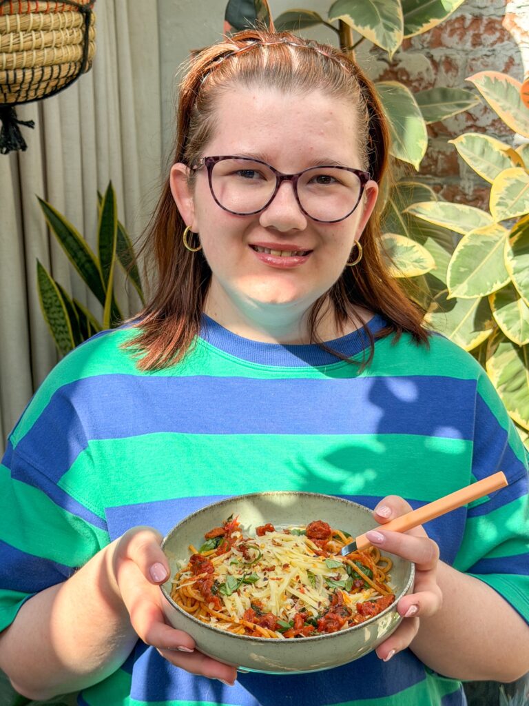 Beaudine met een kom pasta met chorizo in tomatensaus