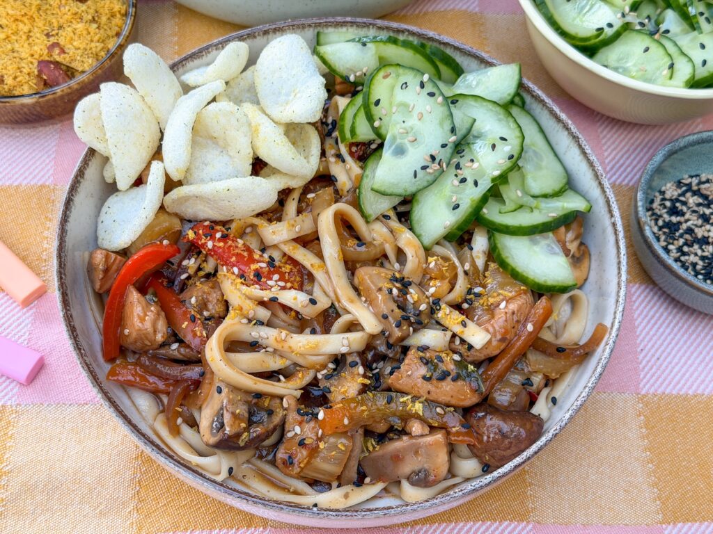 udon noedels met kip in zoet pittige saus met komkommer en kroepoek
