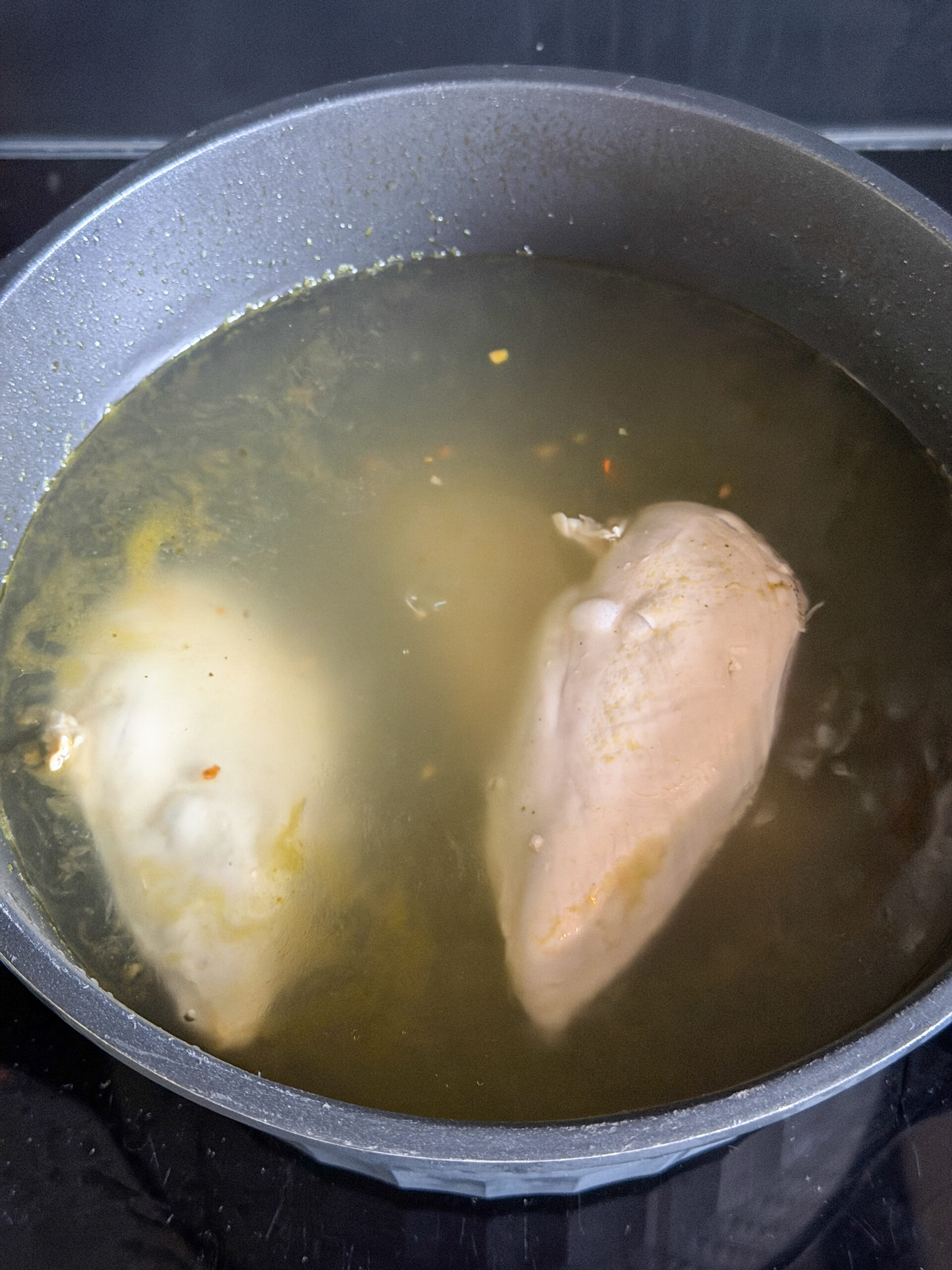 kipfilets worden gaar gekookt in bouillon voor pulled chicken