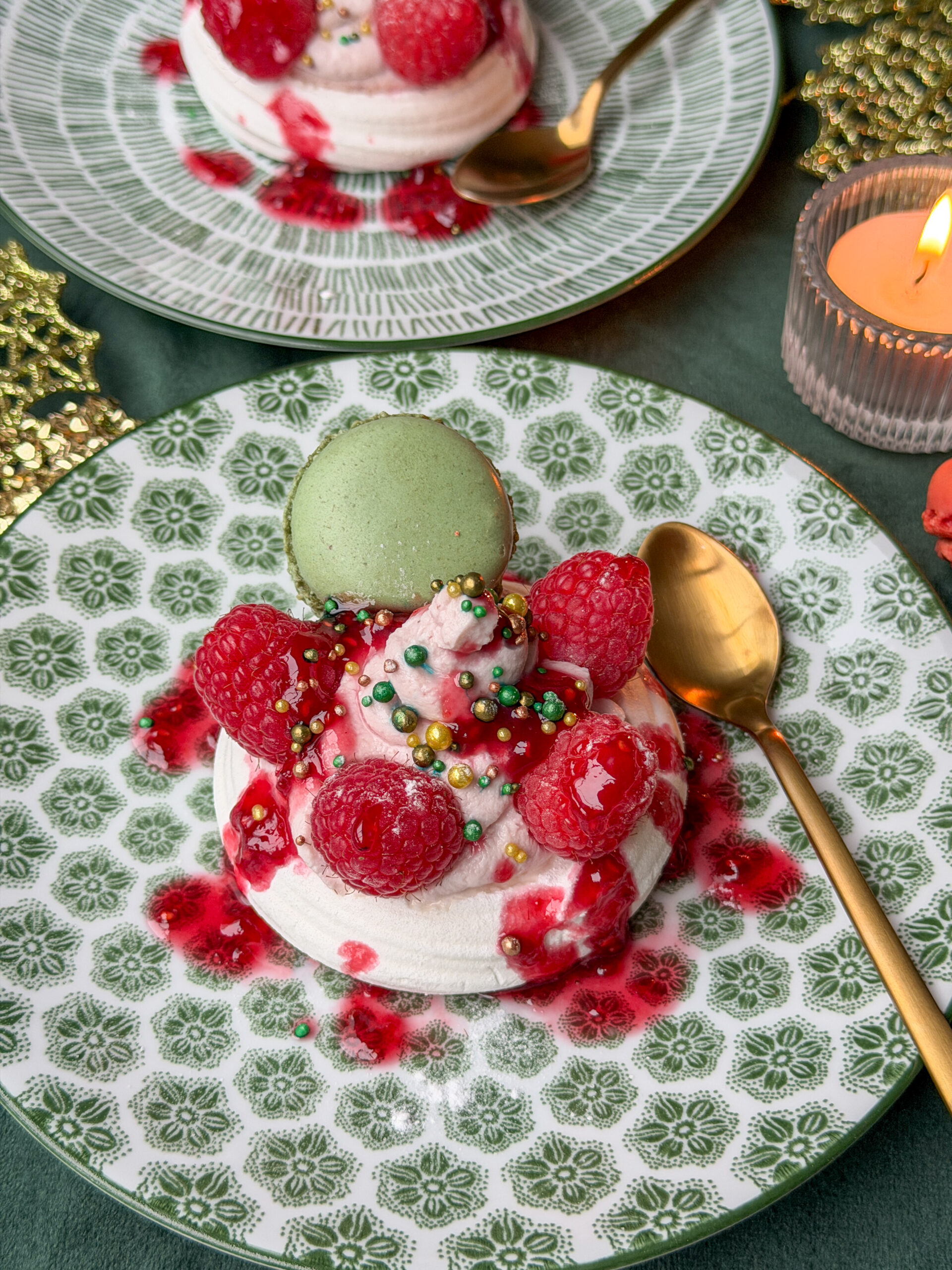 pavlova met frambozen, mascarpone en groene macaron op feestelijk bord