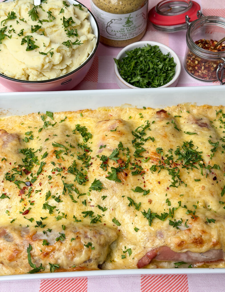 Witlof met ham en kaas uit de oven geserveerd met aardappelpuree