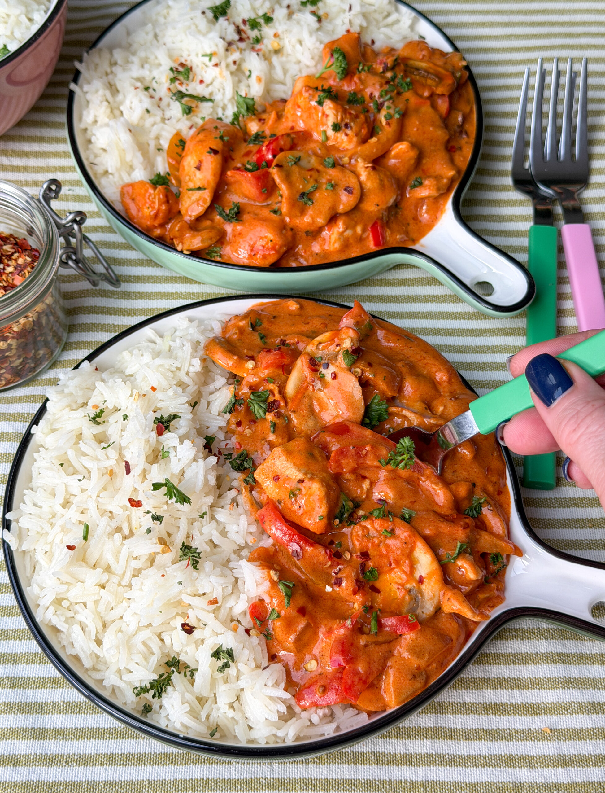 Twee borden met romige kip, paprika en champignons op tafel