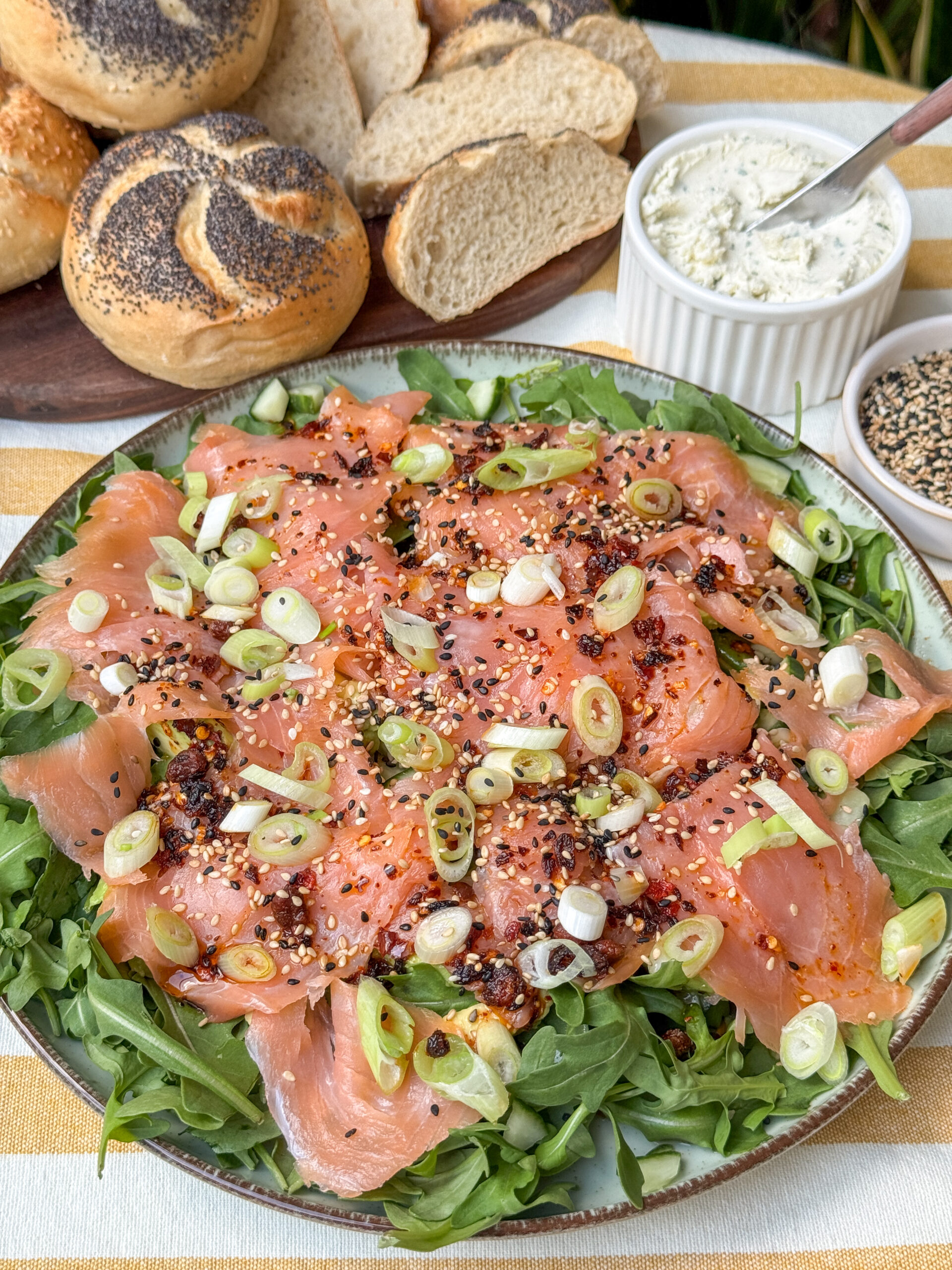 Zalm carpaccio close-up met pittige Aziatische dressing en crispy chili olie, geserveerd met rucola