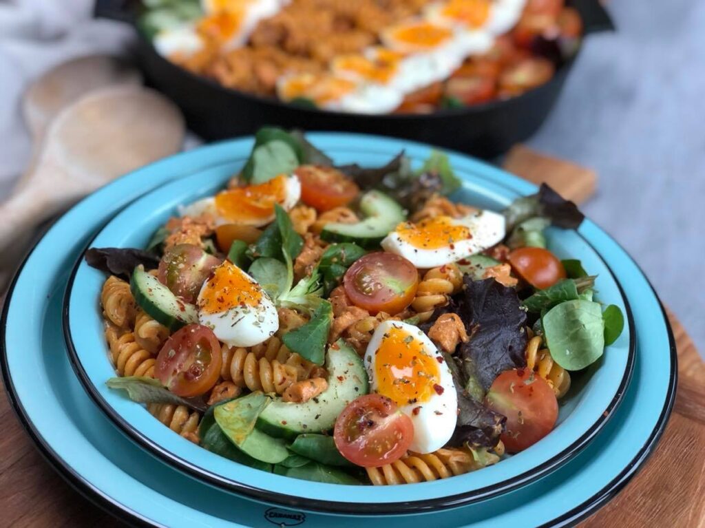 gezonde pastasalade met spekjes, tomaat, komkommer en ei