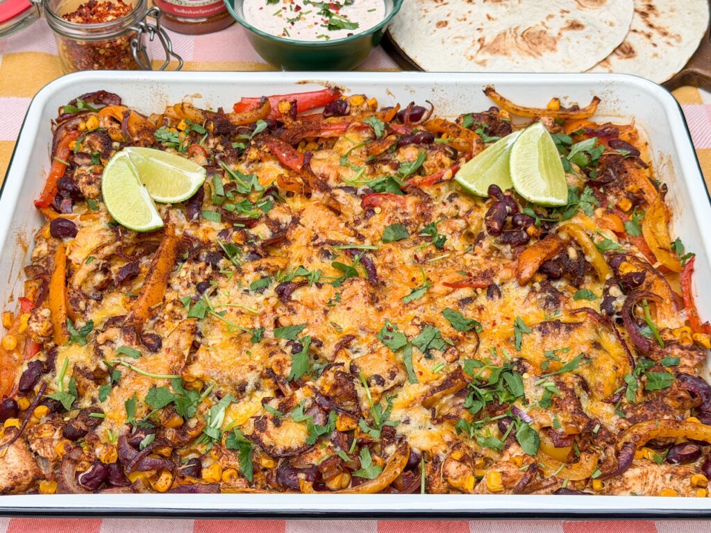 fajita traybake met kip uit de oven geserveerd met tortilla chips, guacamole en limoen