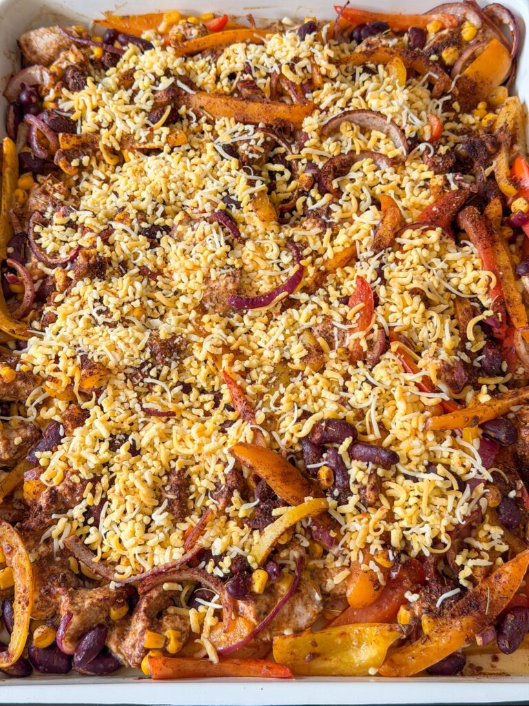 geraspte kaas over de traybake strooien