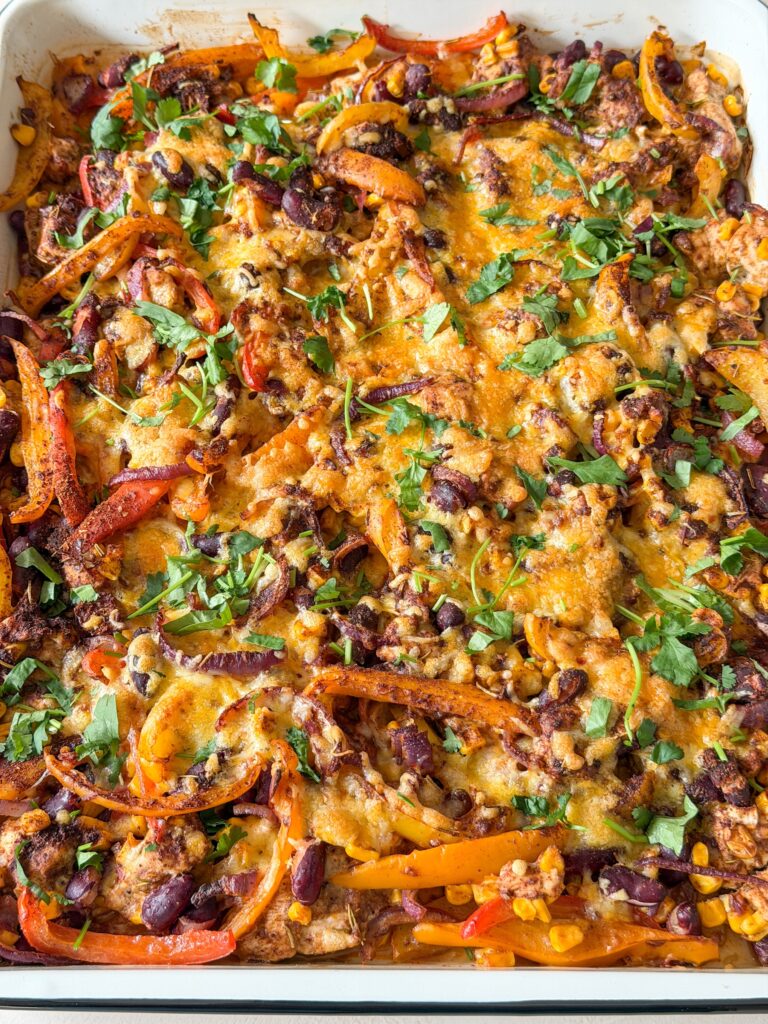 fajita traybake uit de oven met gesmolten kaas en koriander