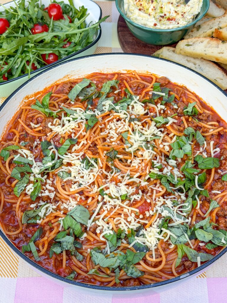 Eenpanspasta met gehakt in tomatensaus in pan met geraspte kaas