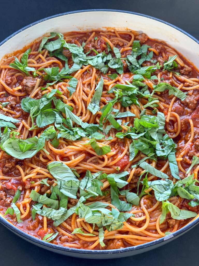 Eenpanspasta met gehakt en tomatensaus basilicum toevoegen