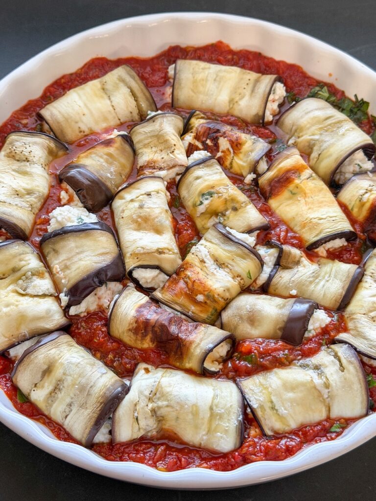 Gevulde aubergine rolletjes in tomatensaus voordat ze de oven in gaan
