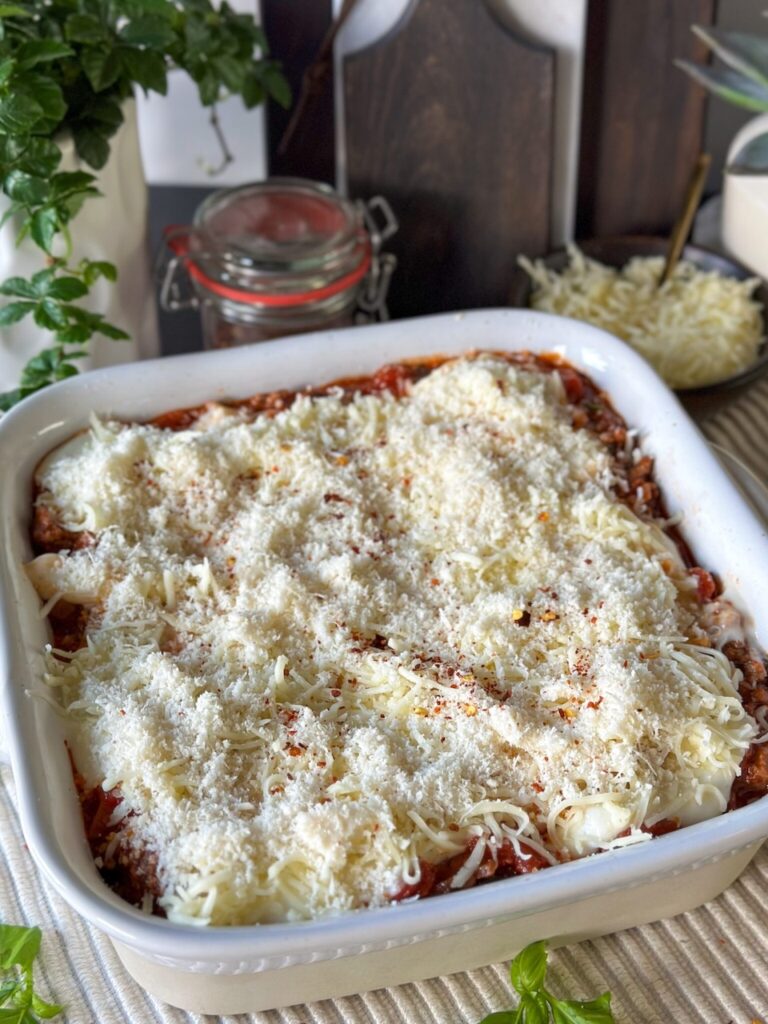 lasagne bestrooien met geraspte kaas voor afbakken