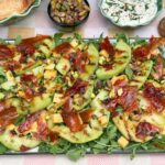Salade met meloen en ham, gegrilde galia meloen, krokante prosciutto, blokjes kaas en pistachenoten