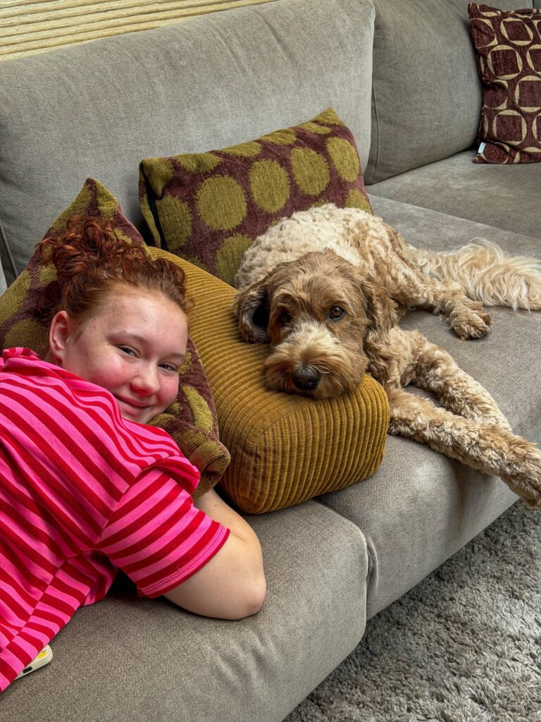 Amaranthe ligt met hond Teun op de bank