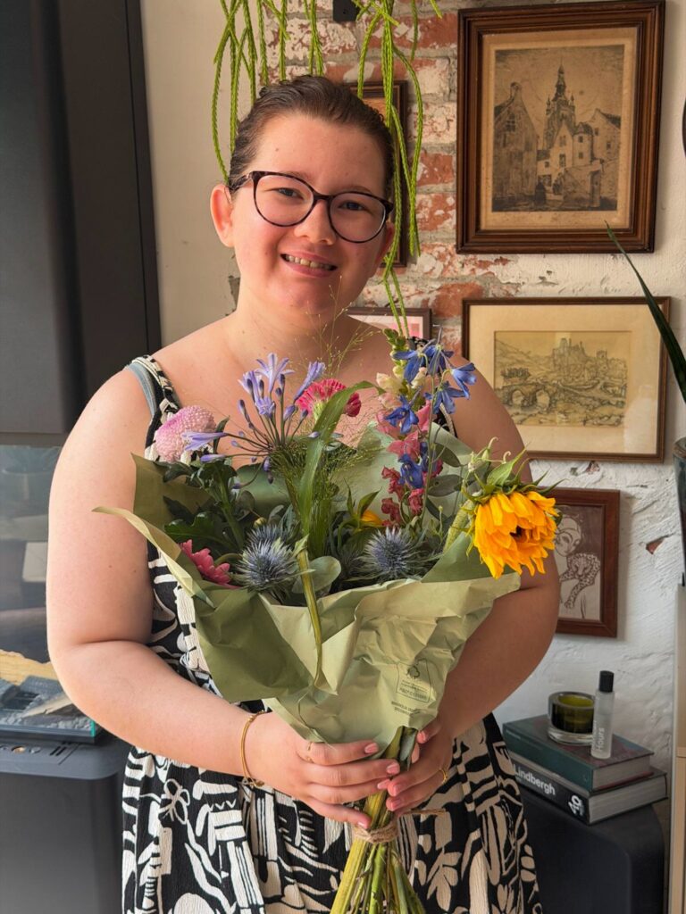 Beaudine houdt bos bloemen vast