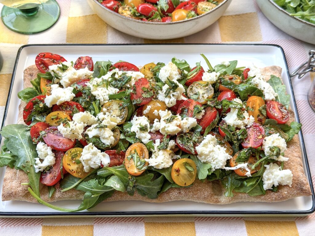 Pinsa caprese met mozzarella, tomaat, basilicum en rucola