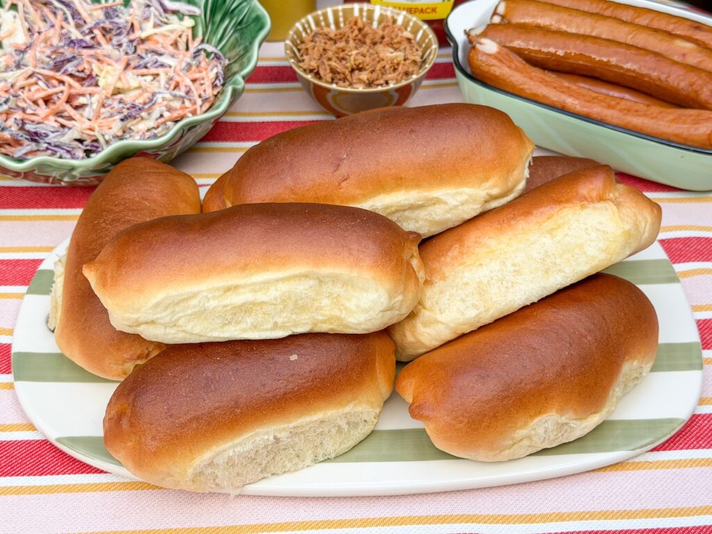 zelfgemaakte zachte hotdog broodjes op een schaal, klaar om te beleggen