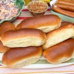 zelfgemaakte zachte hotdog broodjes op een schaal, klaar om te beleggen