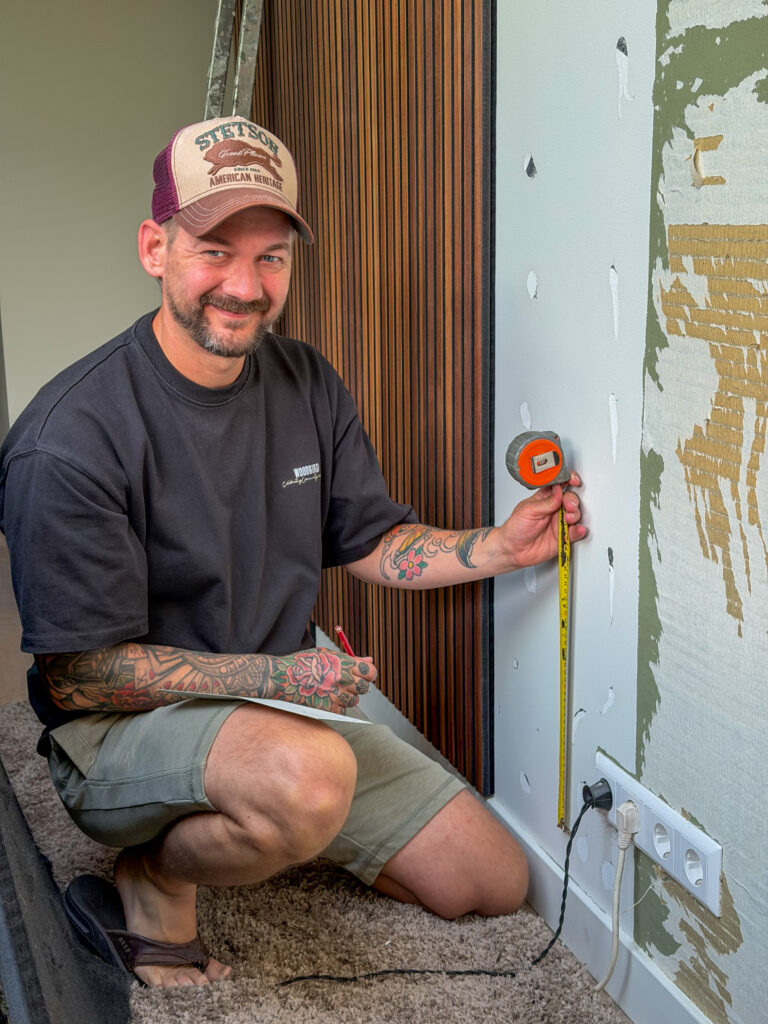 Jan Willem zet de wandpanelen tegen de muur
