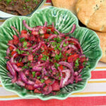 Turkse sumak salade recept met rode ui, tomaat, komkommer en peterselie in een groene schaal
