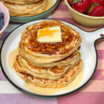 Luchtige American pancakes met roomboter en maple syrup op een bord