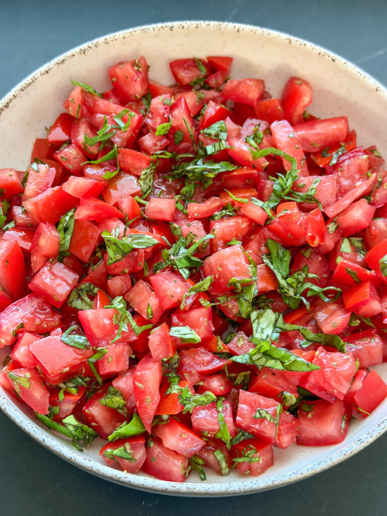 tomatenblokjes gemengd met basilicum en oregano voor bruschetta