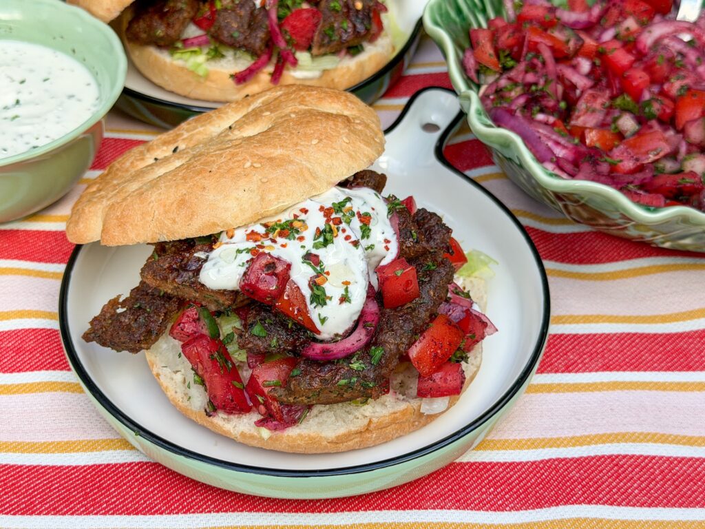 zelfgemaakte kebab uit de oven geserveerd op een Turks broodje met knoflooksaus en Turkse sumak salade