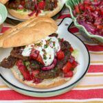 zelfgemaakte kebab uit de oven geserveerd op een Turks broodje met knoflooksaus en Turkse sumak salade