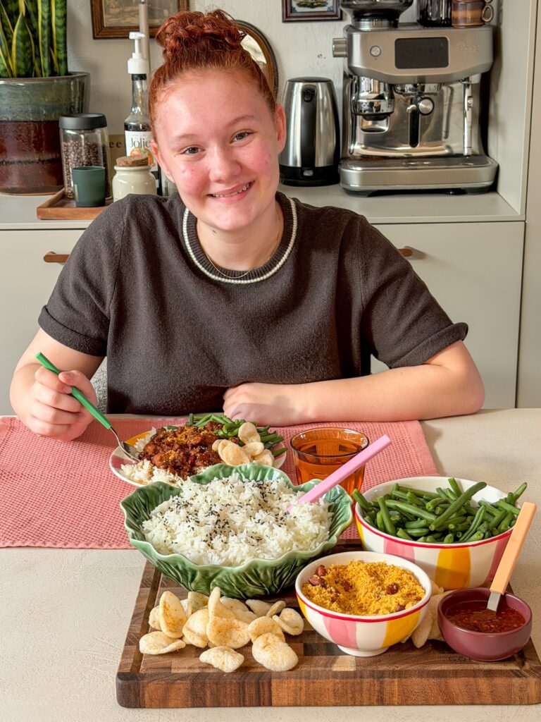 Amaranthe geniet van zelfgemaakte ajam smoor met rijst aan eettafel