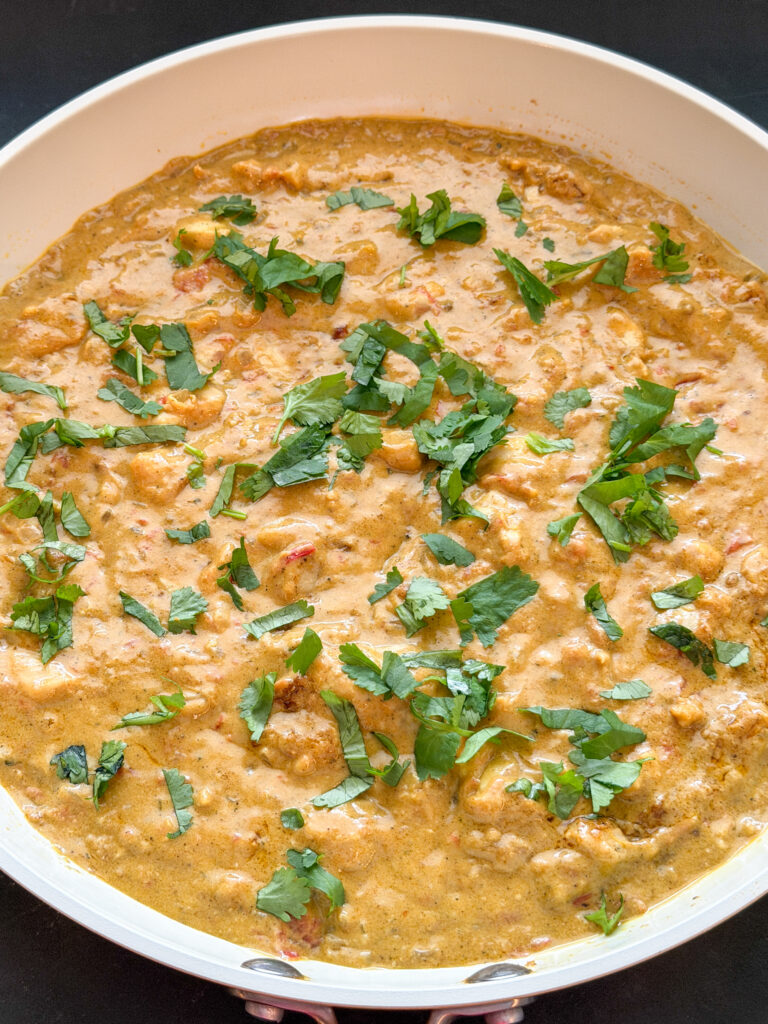 zelfgemaakte kip korma met romige saus en koriander in de pan