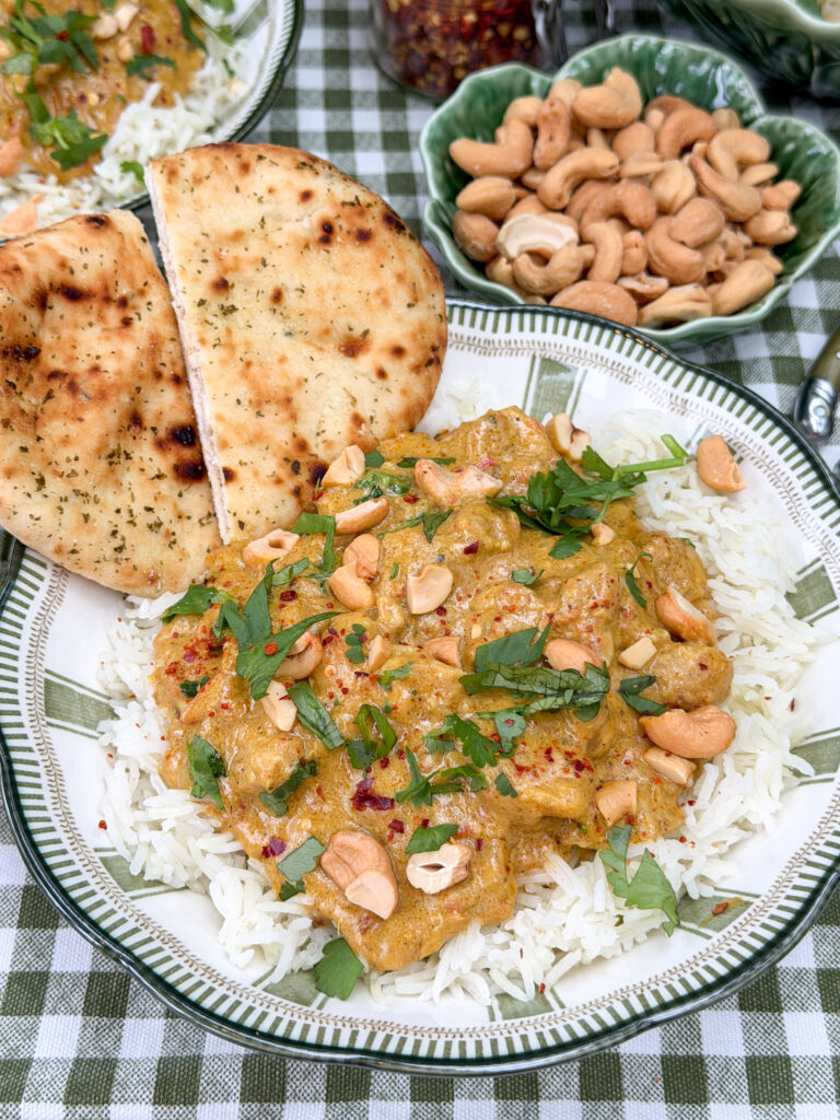kip korma met rijst, naanbrood, cashewnoten en verse koriander