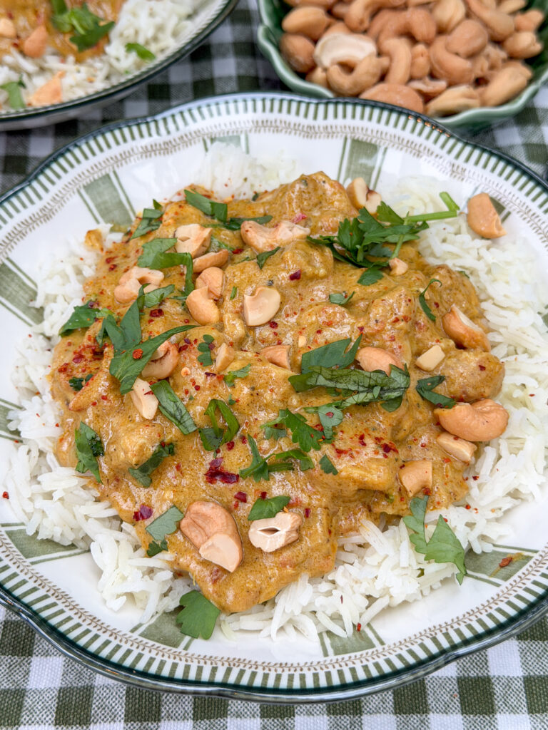kip korma met rijst en cashewnoten geserveerd