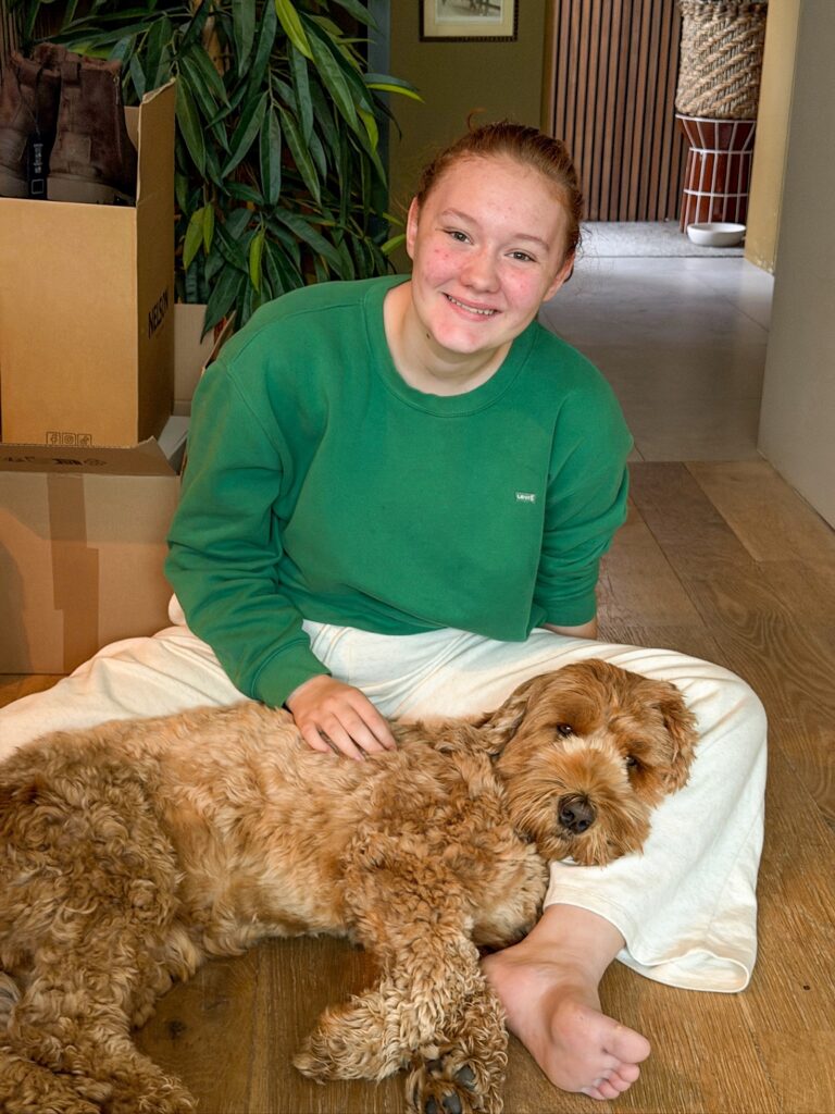 Amaranthe knuffelt met hond Teun op de grond