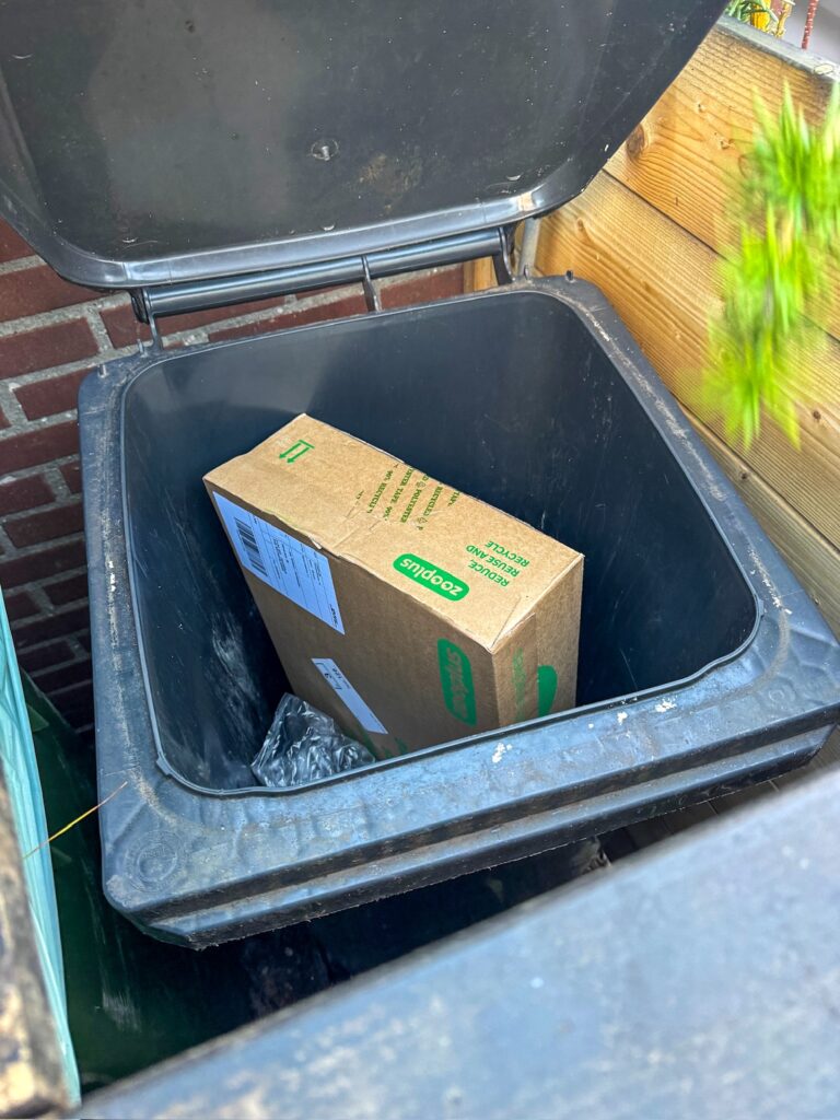 Pakketje die ligt in de prullenbak