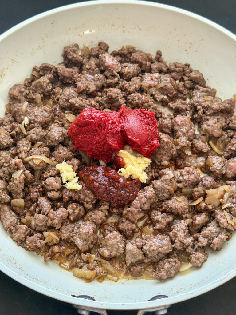 Gebakken gehakt op smaak brengen met chipotle, tomatenpuree en knoflook