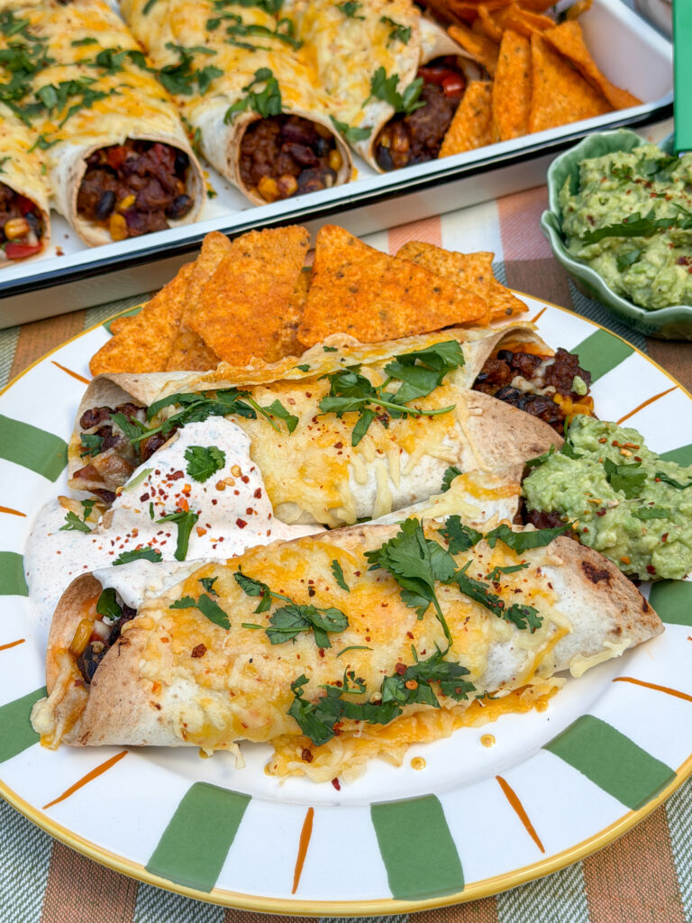 Mexicaanse wraps uit de oven geserveerd met tortillachips, guacamole en creme fraiche dipsaus