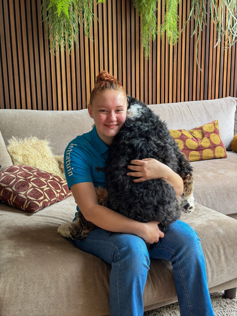 Amarnathe knuffelt met hond Legend