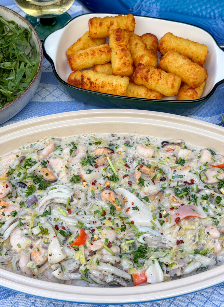 romige zeevruchten geserveerd met aardappelkroketjes en salade