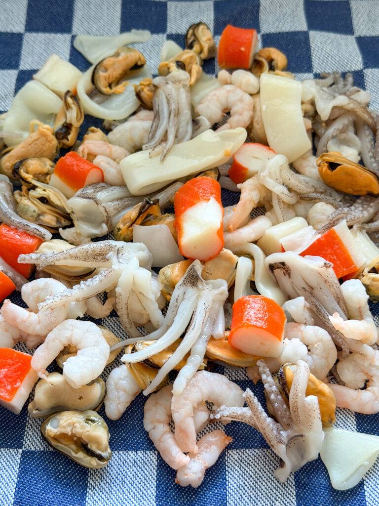 diepvries zeevruchtenmix met garnalen, mosselen, inktvis en octopus droogdeppen op een theedoek