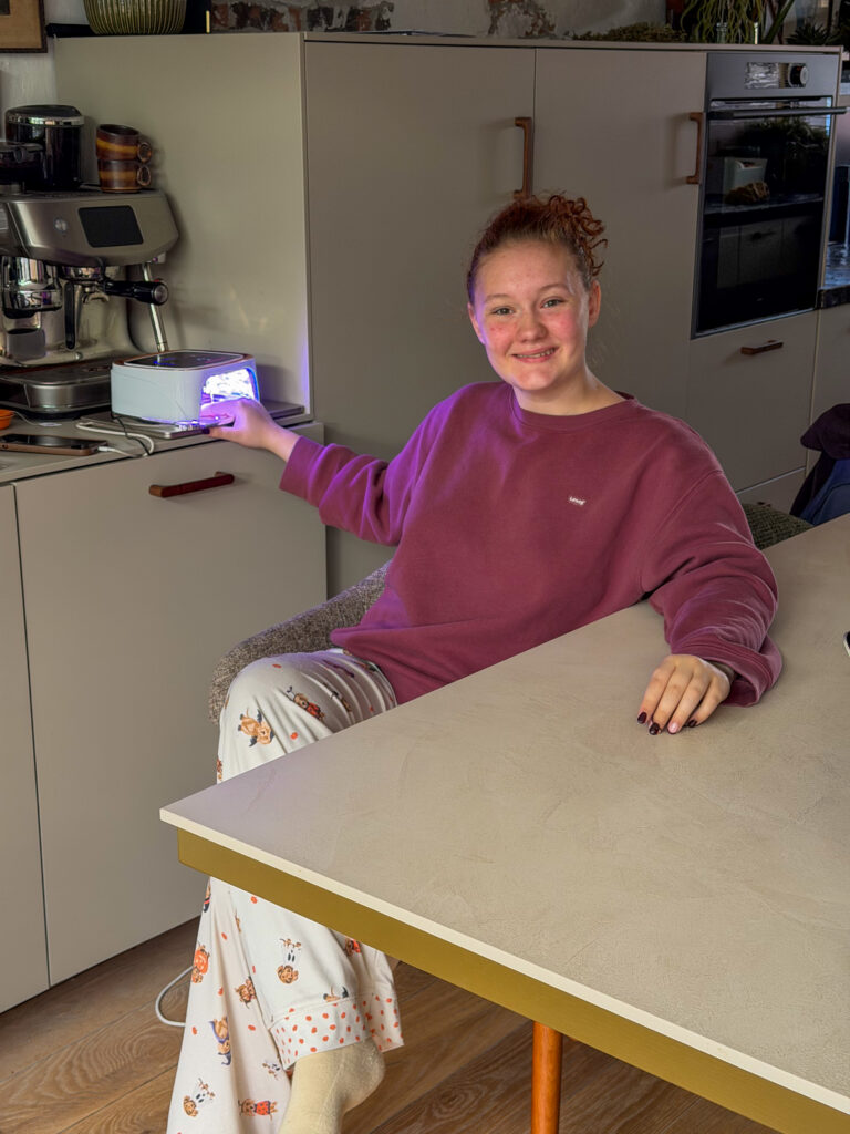 Amaranthe lakt haar nagels aan eettafel